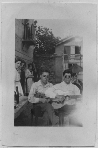 Coppia con chitarra e mandolino davanti alla trattoria Menghetti