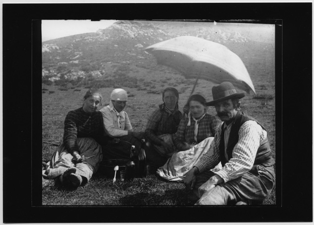 Gruppo di persone ritratto durante un pranzo in montagna nei pressi dell'alpe Musgatina