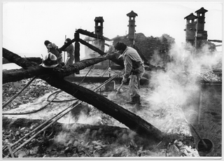 Pompieri intenti nella rimozione di detriti sul tetto del Convento di Bigorio dopo l'incendio