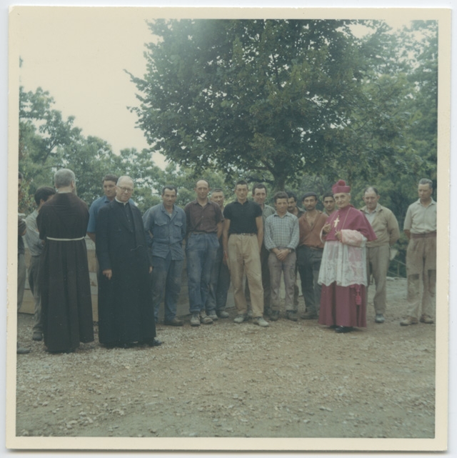 Monsignor Angelo Jelmini in visita al Convento di Bigorio in posa con gli operai durante i lavori di restauro della cappella