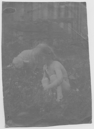 Nudo di bambina in un prato con pecora