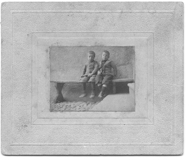 Due bambini seduti sopra ad una panca