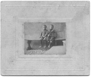 Due bambini seduti sopra ad una panca