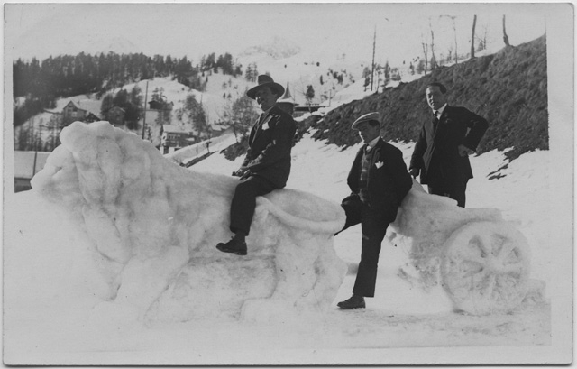 Tre uomini in posa con una scultura di neve