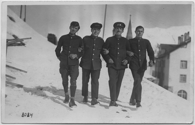 Quattro uomini in divisa sulla neve