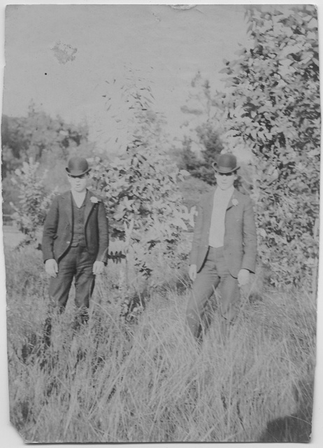 Due uomini in un prato con completo e bombetta