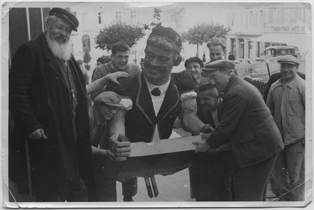 Gruppo di uomini mentre trasporta un busto