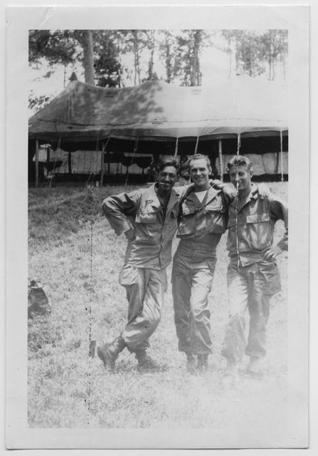 Tre soldati in posa davanti ad un accampamento militare