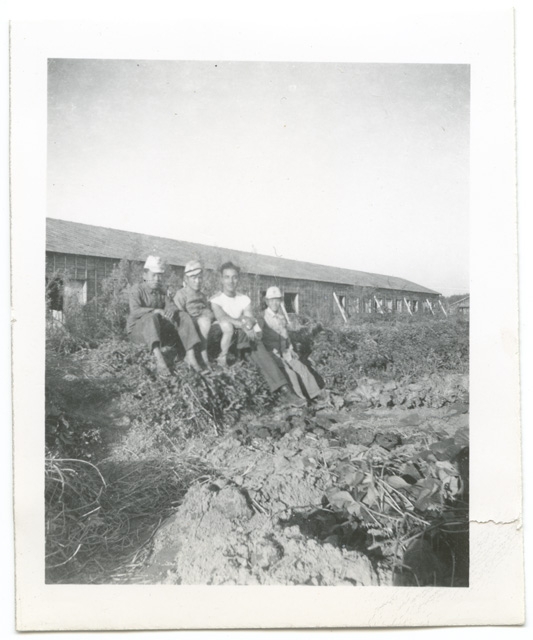 Uomini seduti in un campo militare in Giappone