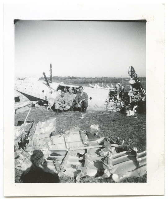 Tre militari in posa con i rottami di un aereo