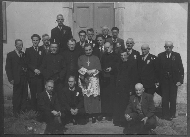 Gruppo di religiosi in visita alla chiesa di Bidogno con al centro Mons. Vescovo Jelmini