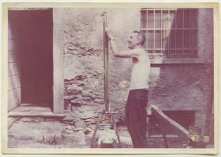 Ugo Gianini mentre vernicia una finestra