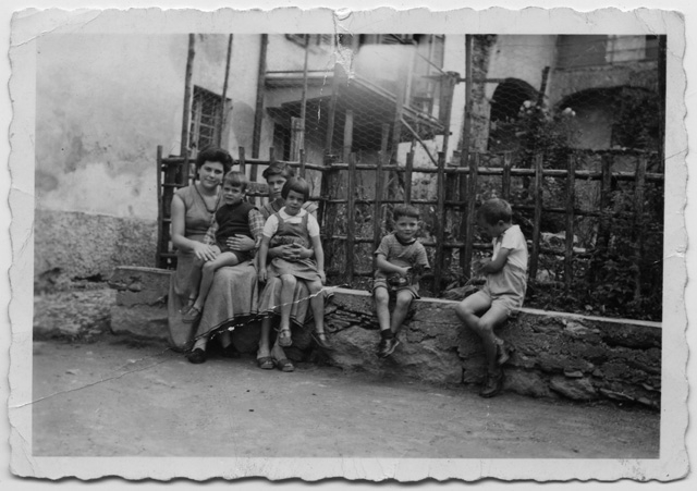 Maria, Brunello, Mirta e Nelly Storni seduti sopra ad un muretto a Sala Capriasca