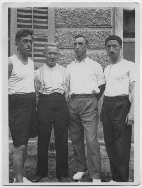 Remo Canonica con tre uomini davanti ad un muro