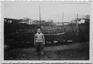 Bambino in posa davanti ad un vigneto a Comano