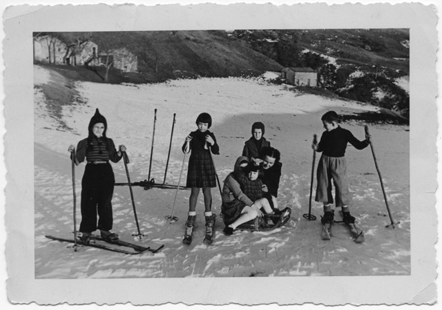 Bambini in posa con sci e slittino ai monti di Nava
