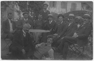 Gruppo di uomini in posa attorno ad un tavolo