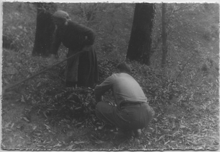 Mario Bernasconi al lavoro nel bosco con un'anziana contadina