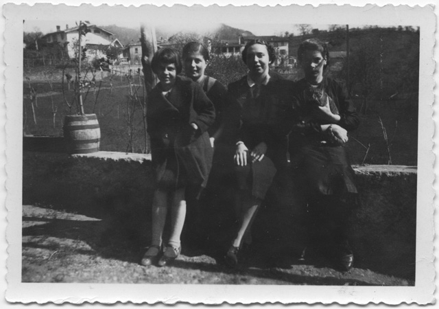 Gruppo di donne sedute su di un muretto a Comano