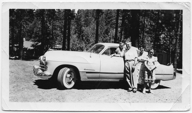Famiglia in posa davanti ad un'automobile