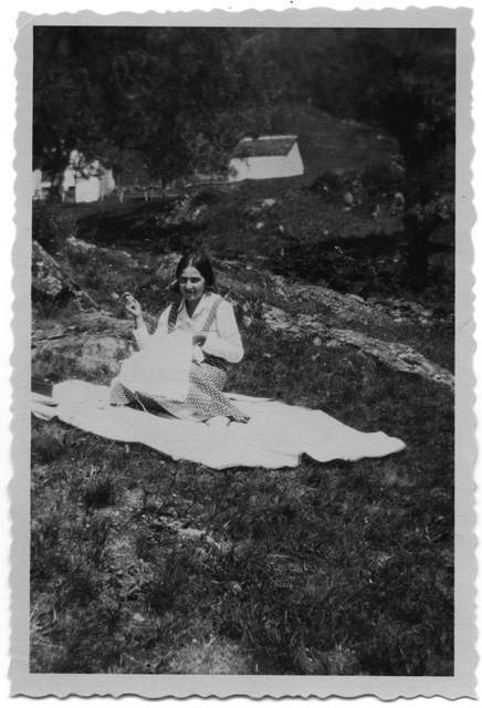 Pia Canonica cuce sopra a un prato in Brena