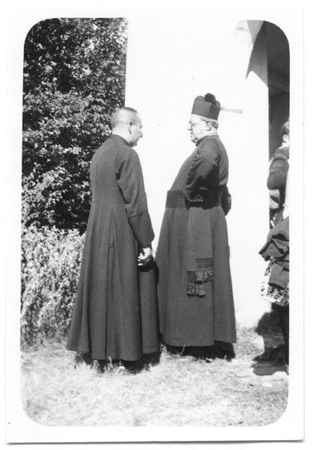 Parroco e (-) a Comano