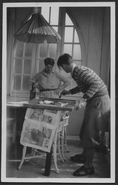 Mario Bernasconi prepara una cornice mentre la moglie Irma lo osserva