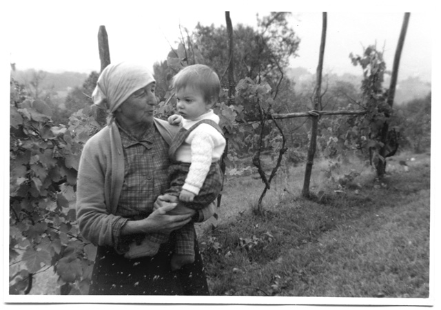 Rosa Pietra con bambino tra i filari della vigna a Comano