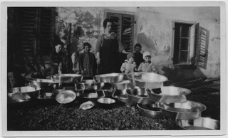 Donna con bambini in posa davanti alla bottega del ramaio a Uznach