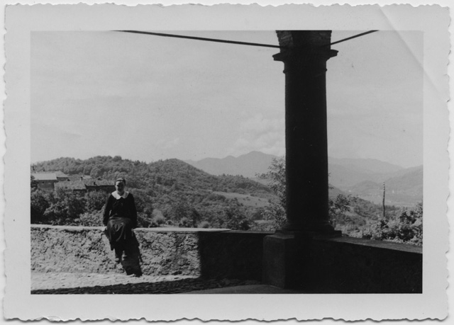 Donna seduta sotto il portico di Santa Maria della Purificazione a Comano