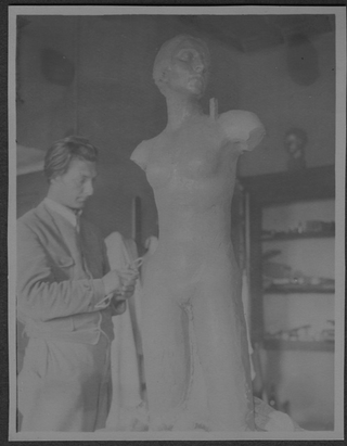 Mario Bernasconi mentre scolpisce un torso con testa