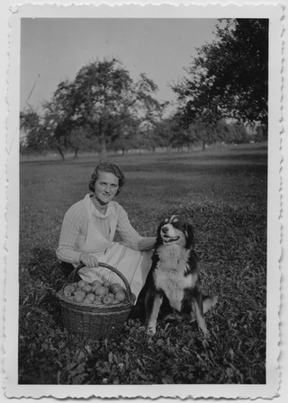 Ragazza con cane in posa sopra a un prato