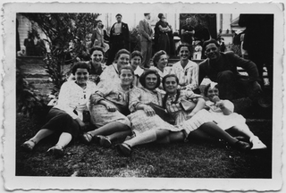 Ragazze della parrocchia di Comano in posa su di un prato