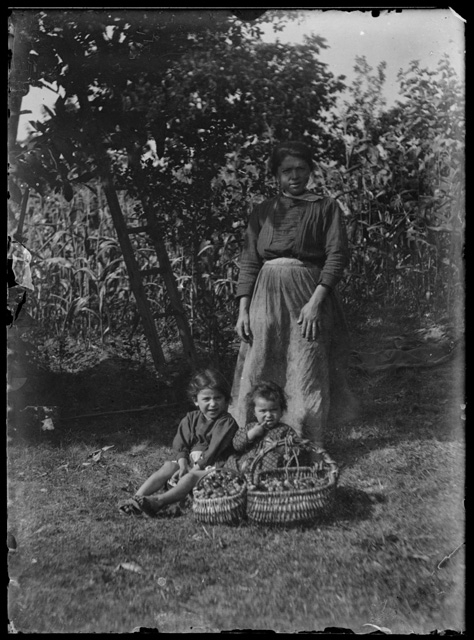 Donna con bambine e canestri di frutta
