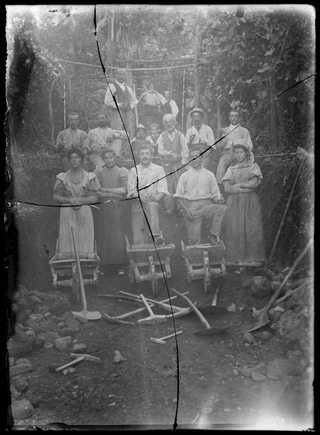 Gruppo in posa in un cantiere con pale e carriole