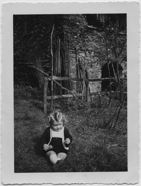 Bambino seduto in giardino