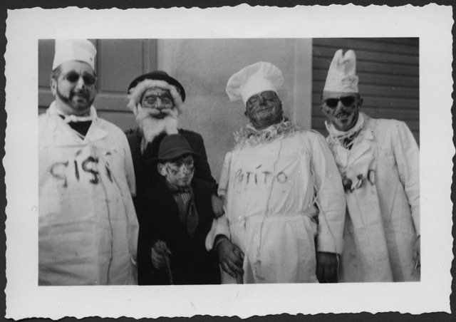 Uomini con bambino in posa al carnevale di Tesserete