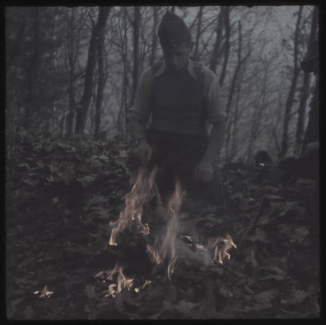 Soldato che cura un falò durante la festa della castagna a Cassina d'Agno