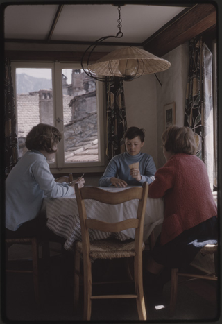 Donna con due bambini mentre giocano a carte nel soggiorno di casa Meili a Vaglio