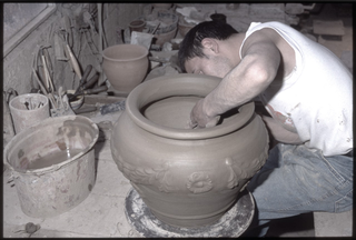 Ceramista mentre modella un vaso