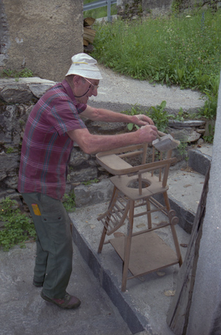 Falegname mentre spolvera un seggiolone