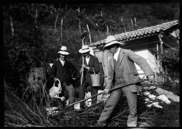 Uomini in posa con attrezzi agricoli