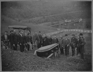 Gruppo di uomini attorno a una bara