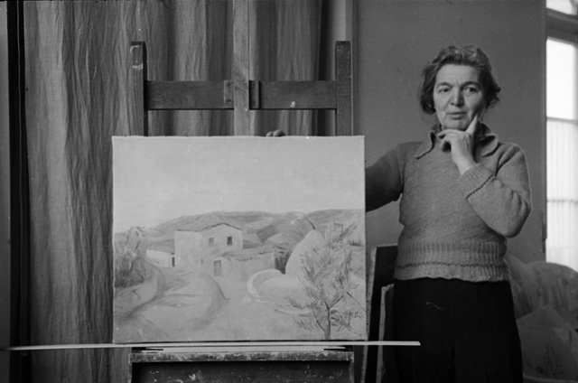 La pittrice Regina Conti in posa con un il dipinto "Monti di Roveredo"