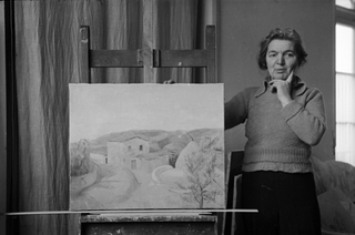 La pittrice Regina Conti in posa con un il dipinto "Monti di Roveredo"