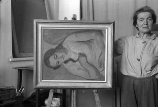 La pittrice Regina Conti in posa con un suo dipinto