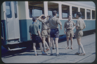 Scout bernesi della Roverrotte Cepheus davanti a un convoglio della ferrovia Lugano-Tesserete