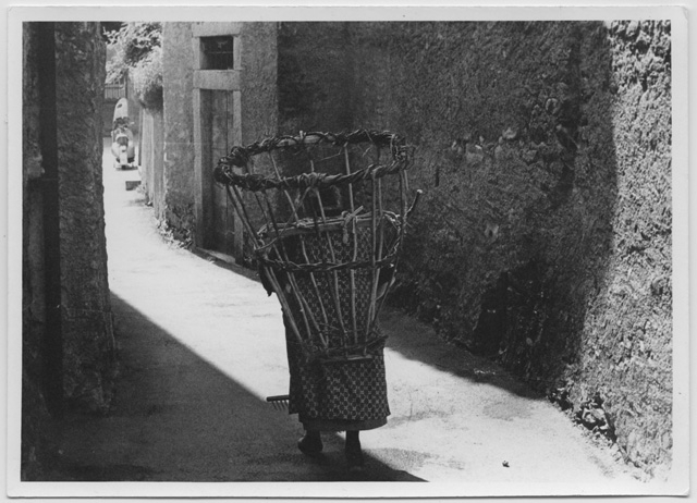 Teresa Antonini con la gerla nel nucleo di Lugaggia