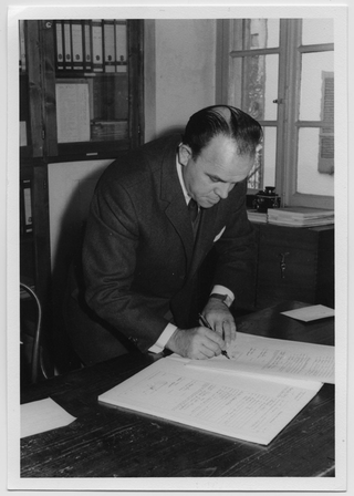 Ritratto di Claudio Morandi mentre firma dei documenti in municipio a Lugaggia